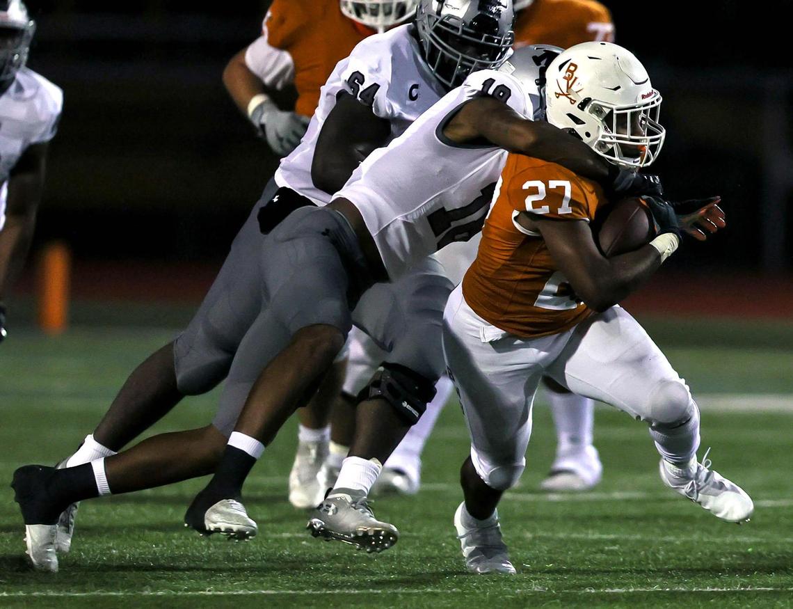 Arlington Bowie running back Kameron Sanders (27) gets rapped up by Arlington Martin linebacker Morice Blackwell Jr (18) after a short gain during the first half of a high school football game, Friday night, November 6, 2020 played at Wilemon Field in Arlington, Tx. (Steve Nurenberg Special to the Star-Telegram)