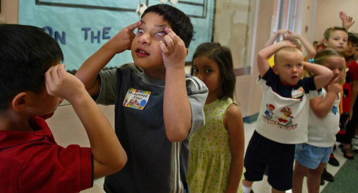 Aug. 5, 2002: Kindergartners Sasawat Satumtira, 5, and Muhammad Khan, 5, find they have a love of making funny faces in common on the first day of school at Bluebonnet Elementary School in Fort Worth. The boys were waiting with the rest of Samantha Davis’ class to continue their tour of the brand new school in Keller ISD.
