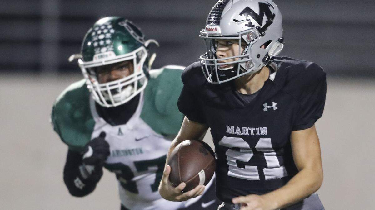 Martin quarterback Zach Mundell is chased by Arlington defensive back Richard Toney (37) during the first half of a high school football game at UTA Maverick Stadium Friday, Oct. 19, 2018. Martin led 18-14 at the half. (Special to the Star-Telegram Bob Booth)

