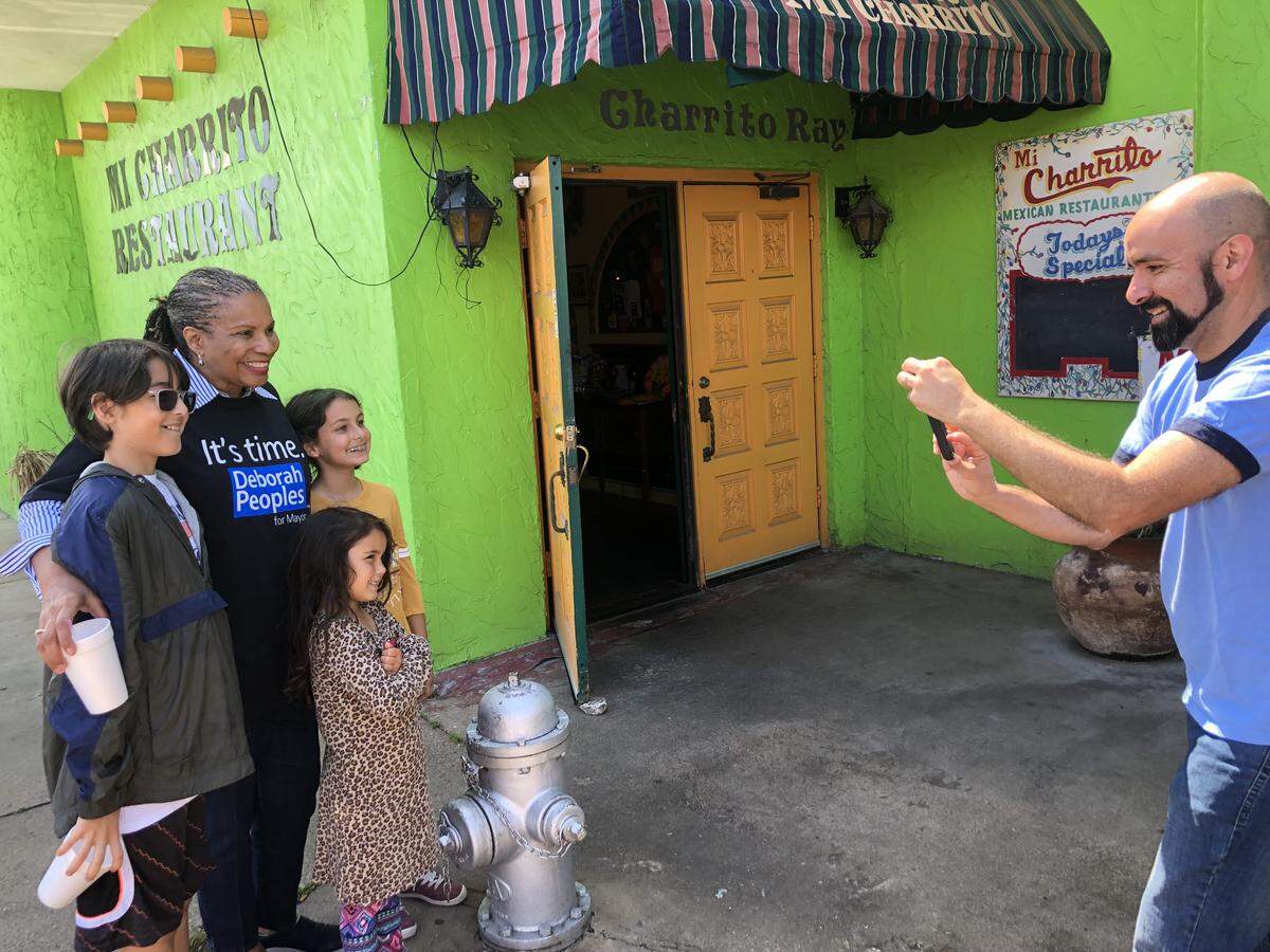 Mayoral candidate Deborah Peoples takes photos outside Mi Charrito resturant at a Get Out the Vote rally on Election Day in Fort Worth.