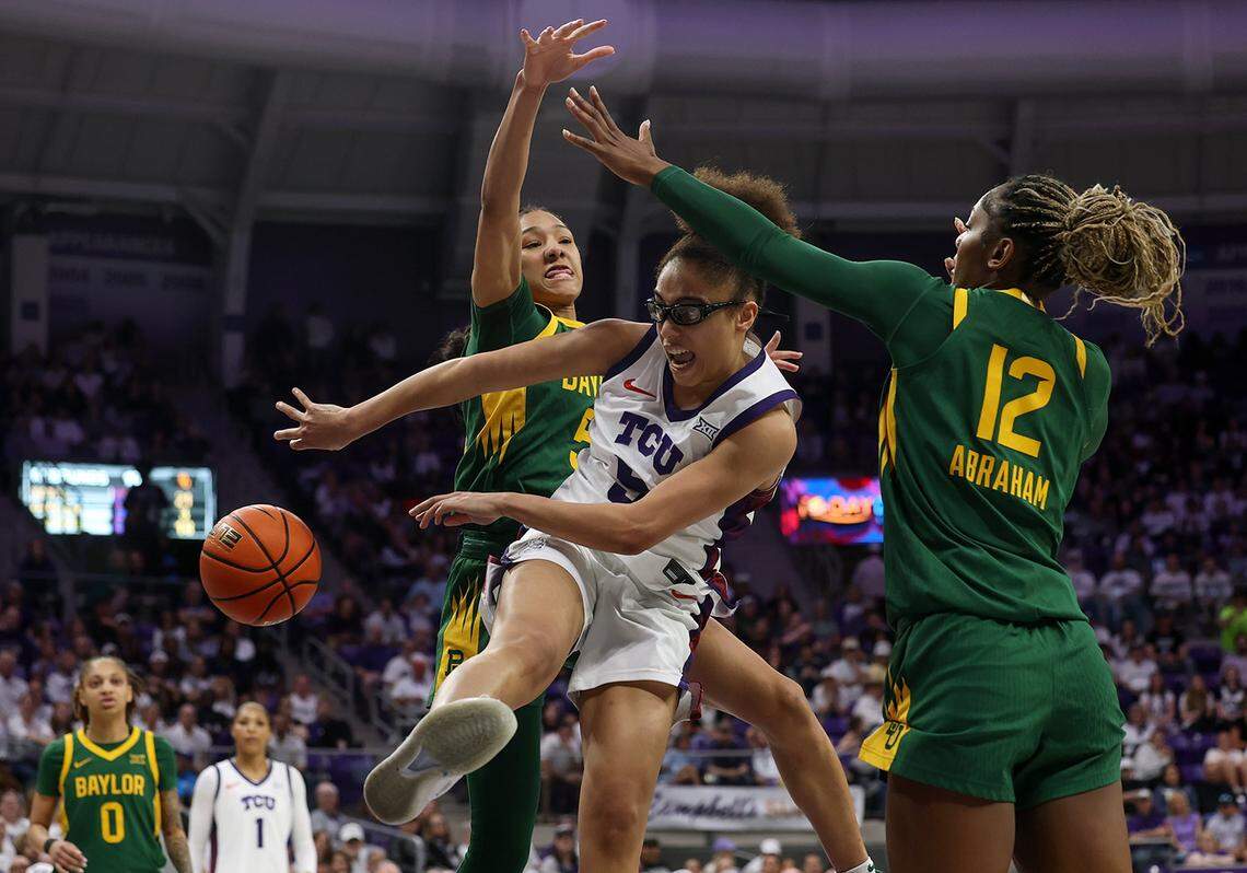 Texas Christian University guard Olivia Miles passes the ball backwards while defended by Baylor forwards Darianna Littlepage-Buggs, left, and Kyla Abraham on Sunday, March 1 2026, at Schollmaier Arena in Fort Worth.