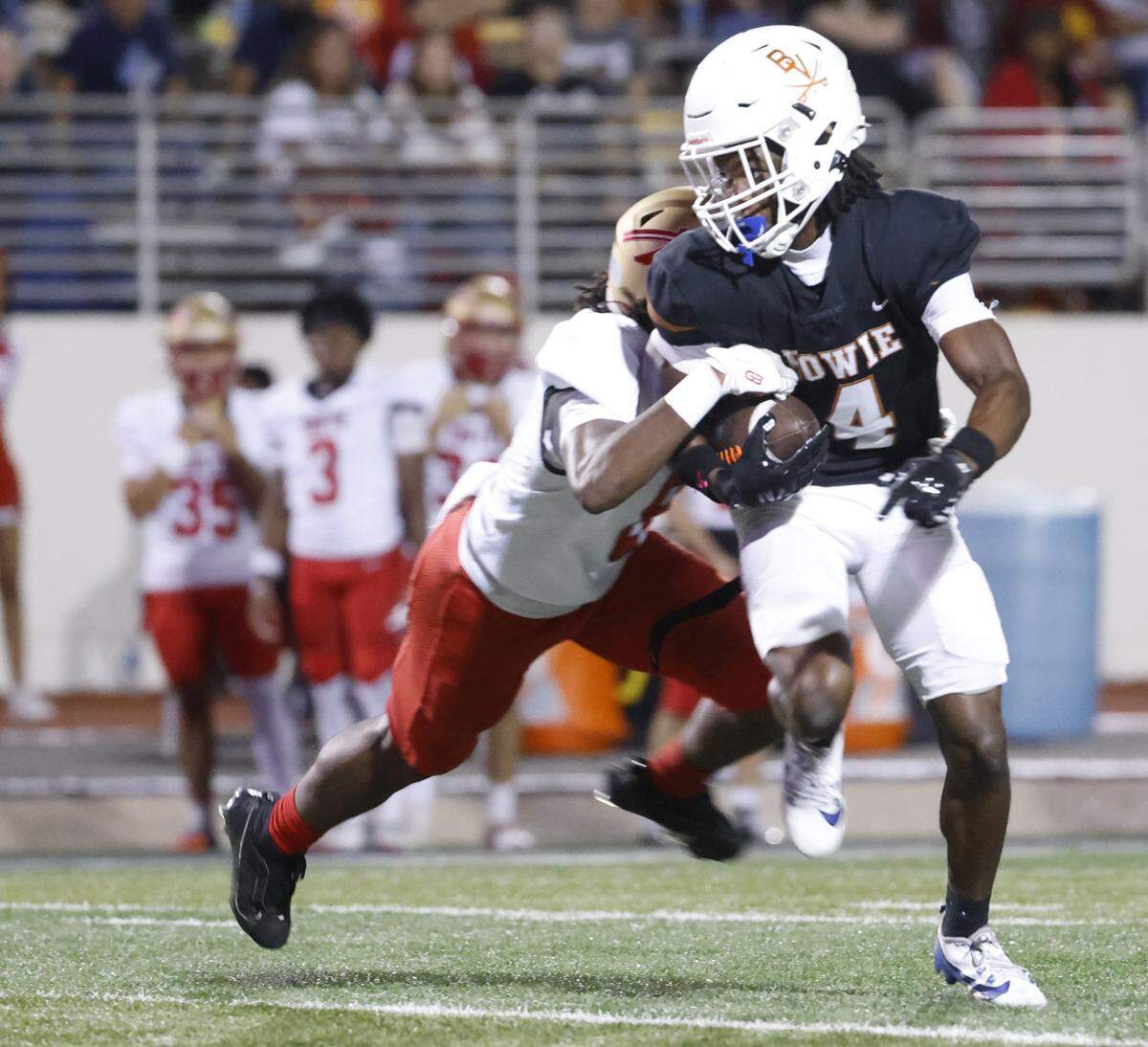 Bowie wide receiver Keidric Osunde-Brown (4) is stopped by South Grand Prairie corner back Marcanthony Wiley (8) after a catch during the first half of a UIL football game between South Grand Prairie and Arlington Bowie at UTA Maverick Stadium in Arlington, Texas, Thursday Nov. 06, 2025.