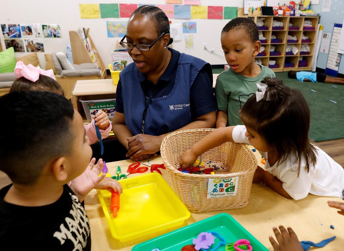 Teacher assistant Candice Franklin helps children as they play at a station while attending pre-K at The Morris Foundation Child Development Center on Tuesday, Sept. 24, 2024.