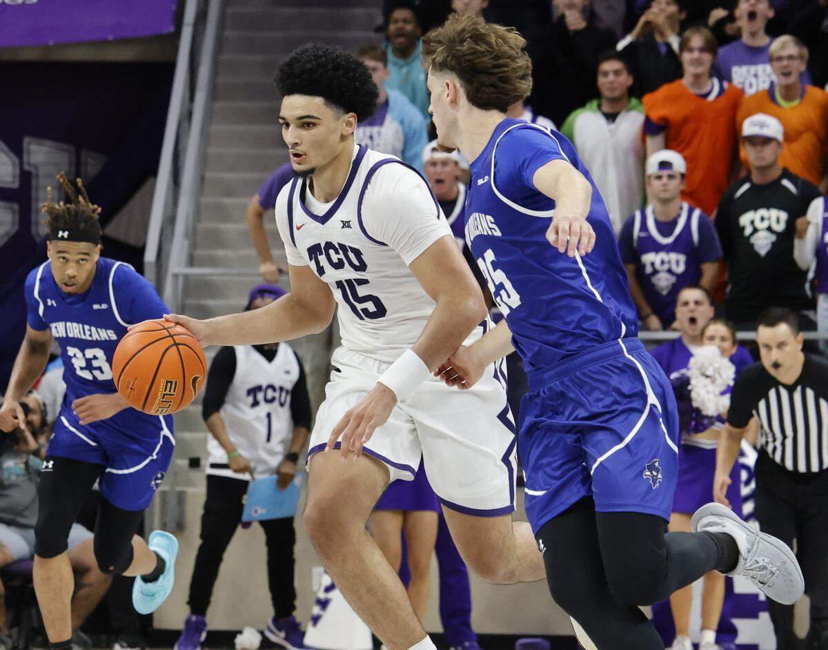TCU forward David Punch (15) brings the ball down court in front of New Orleans forward Enzo Boudouma (25) during the second half of a NCAA basketball game between New Orleans University and TCU at Schollmaier Arena in Fort Worth, Texas, Monday Nov. 03, 2025. The Horned Frogs dropped their home opener 78-74 to the Privateers.