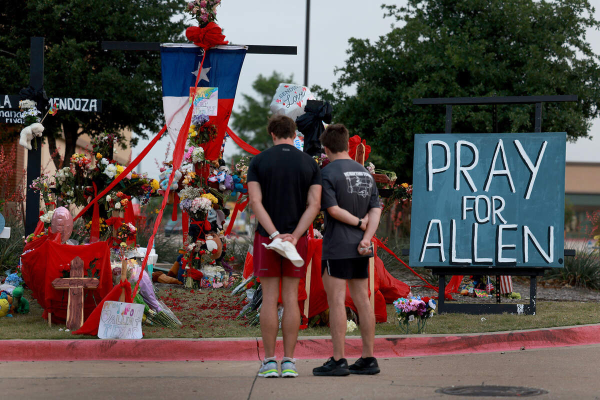 People visit a memorial near the scene of mthe ass shooting at Allen Premium Outlets on May 9.