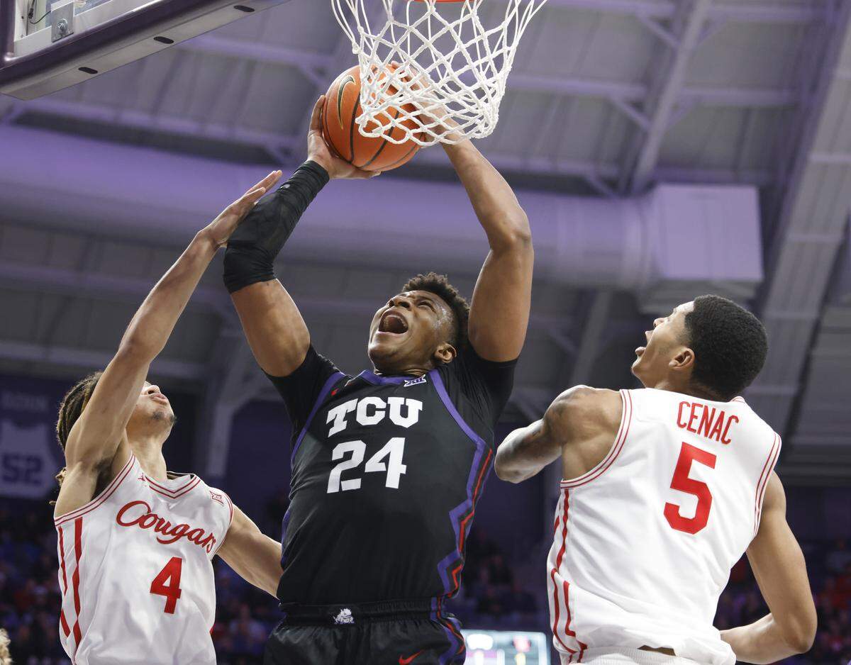 TCU forward Xavier Edmonds (24) drops in one defended by Houston guard Kingston Flemings (4) and forward Chris Cenac Jr. (5) during the first half of a NCAA basketball game between the University of Houston and TCU at Schollmaier Arena in Fort Worth, Texas, Wednesday Jan. 26, 2026