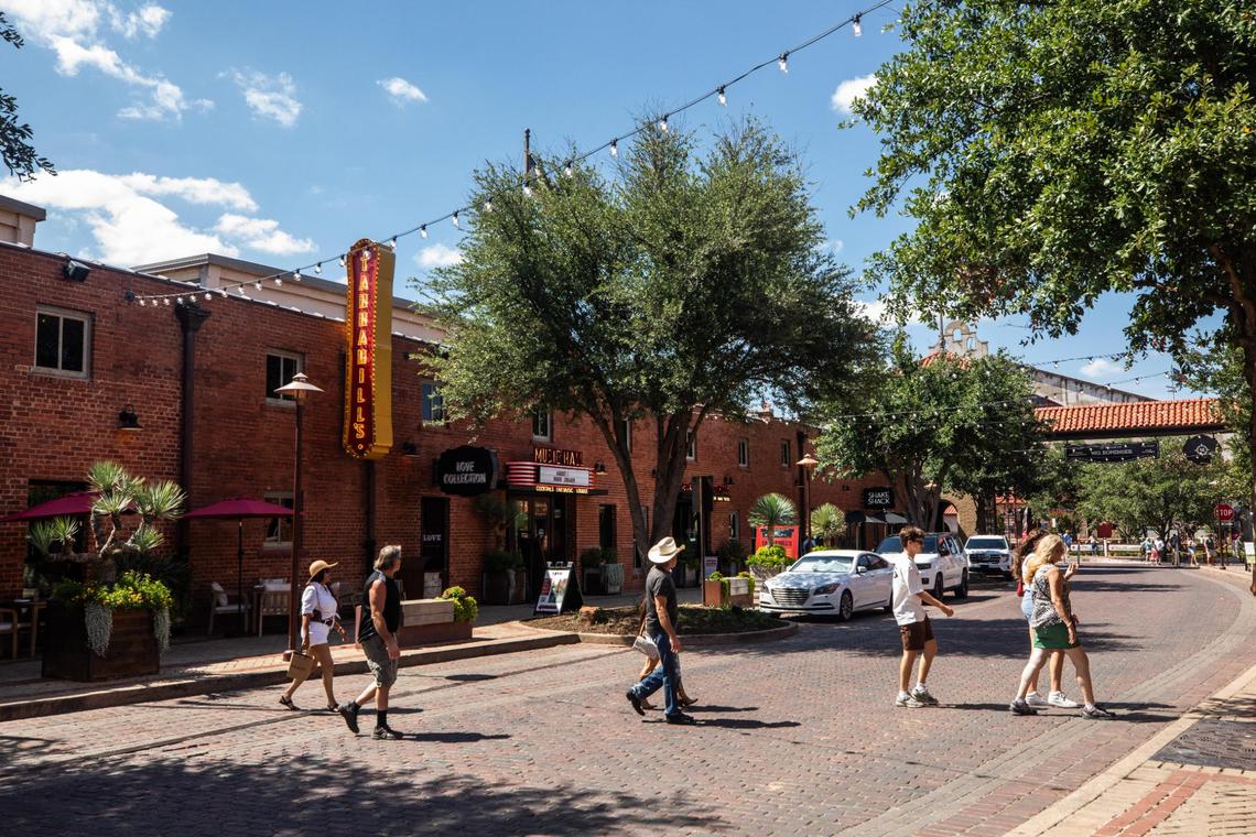 A group walks by restaurants on Mule Alley at the Fort Worth Stockyards in July.
