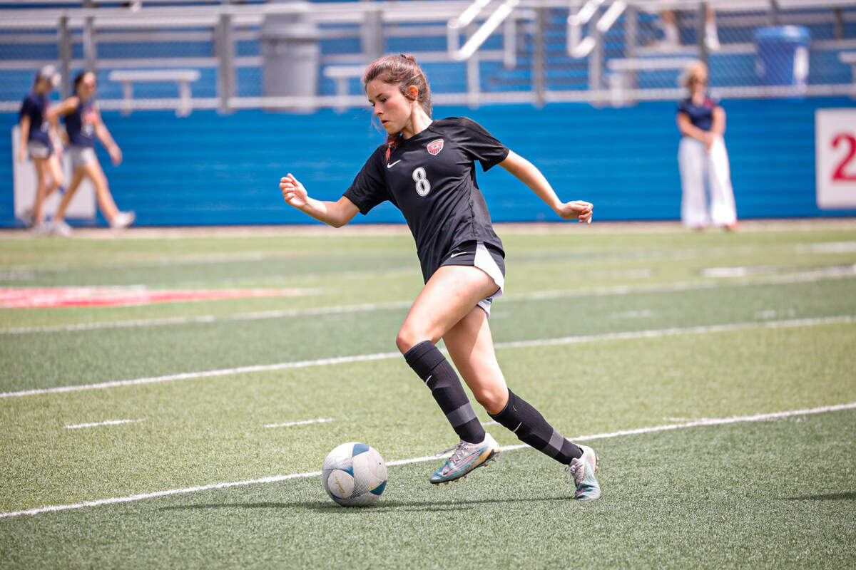 Colleyville Heritage freshman midfielder Addison Bizjack dribbles in a Class 5A state championship game against Frisco Wakeland at Birkelbach field on April 13, 2024.