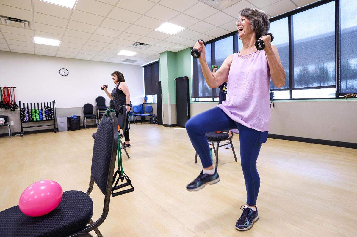Mitzi Gault, left, and Patti Crummel participate in an exercise using weights as part of their Nutrition Exercise and Attitude for Tomorrow program.
