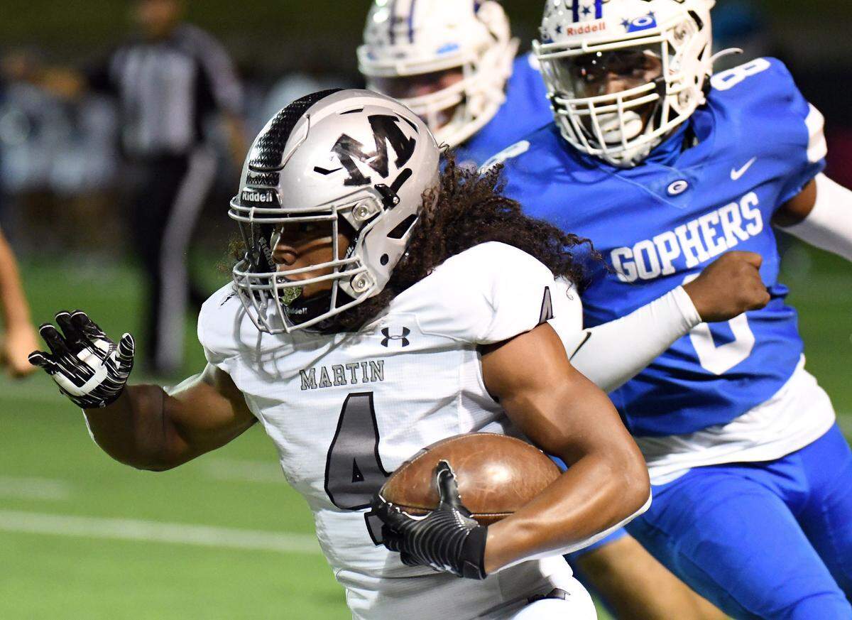 Arlington Martin’s Zaire Barrow, left races past Grand Prairie ‘s Jacquese Hurst for a big gain in the first quarter of their district 8-6A football game Friday, October 29, 2021 at the Gopher Warrior Bowl in Grand Prairie, Texas. Special/Bob Haynes