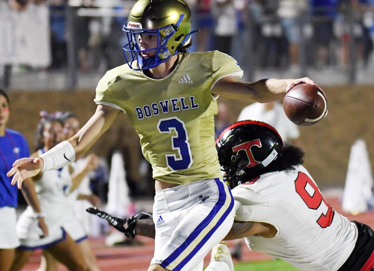 Boswell quarterback Sawyer Farr, left, runs past Trinity’s Corey Johnson for the touchdown to take a 38-26 lead in the fourth quarter of Friday’s September 16, 2022 District 3-6A football game at Boswell High School Pioneer Stadium in Fort Worth, Texas. Boswell went on to win 45-26. Special/Bob Haynes