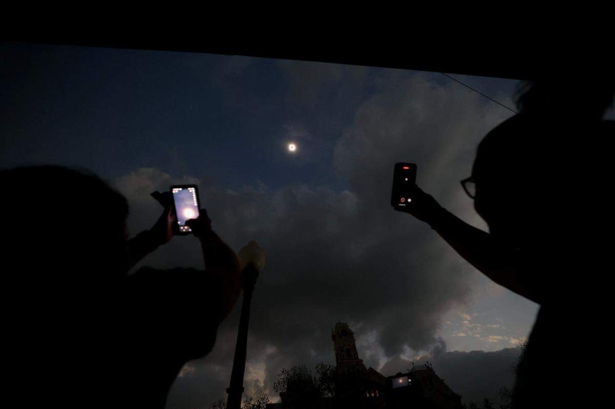 Eclipse viewers attempt to photograph the totality with their phones in Hillsboro on Monday, April 8, 2024.