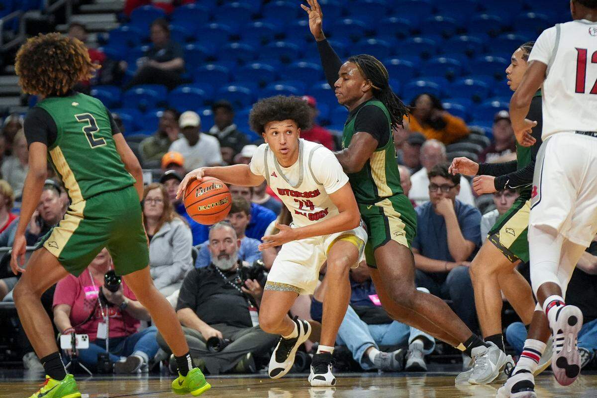 Hitchcock’s Lloyd Jones III (24) maneuvers against the defense of San Antonio Cole’s Kenny Atunrase (23) in a Class 3A state semifinal on Thursday, March 7, 2024 at the Alamodome in San Antonio, Texas. Jones tallied 17 points as Hitchcock defeated Cole 57-40.