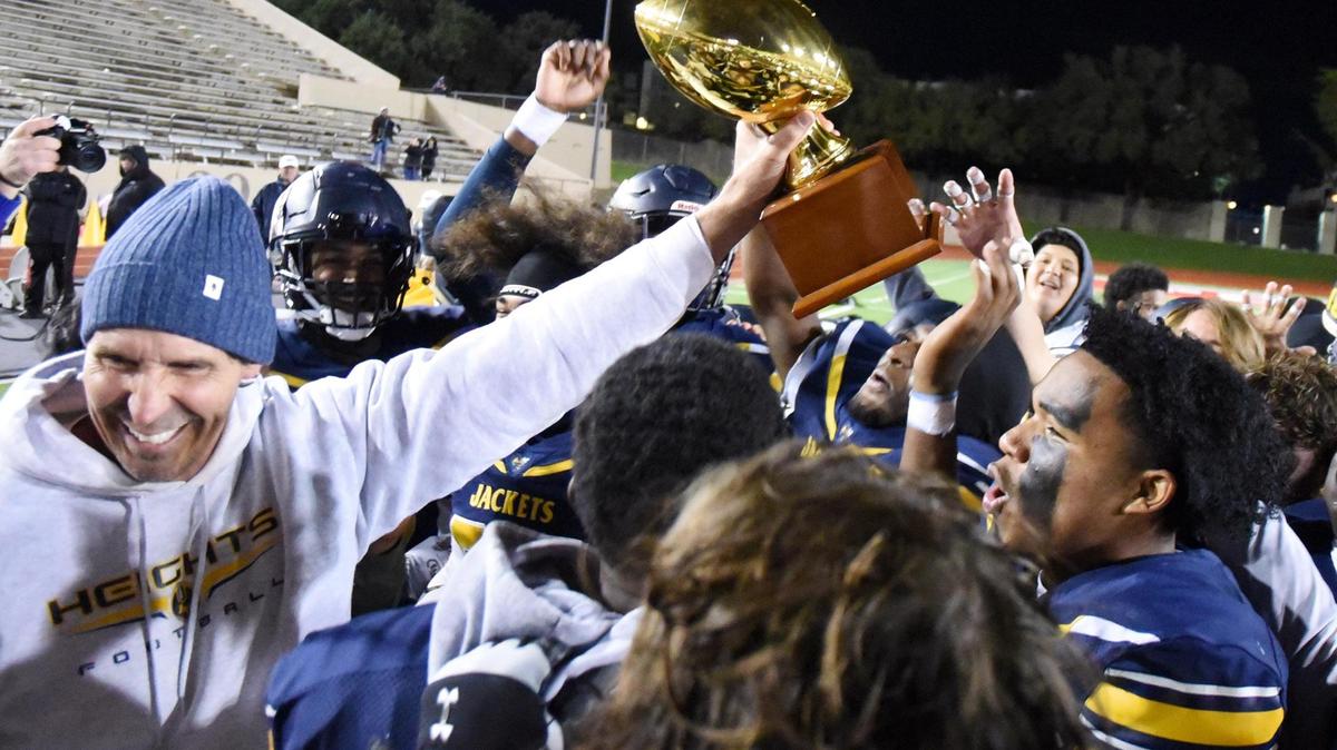 Arlington Heights Head Coach Phil Young, left holds out the he trophy as team members celebrate after beating Frisco Independence High School 40-21 in Friday’s November 11, 2022 5A Division 2 Bi-District football game at Farrington Field in Fort Worth, Texas. Special/Bob Haynes