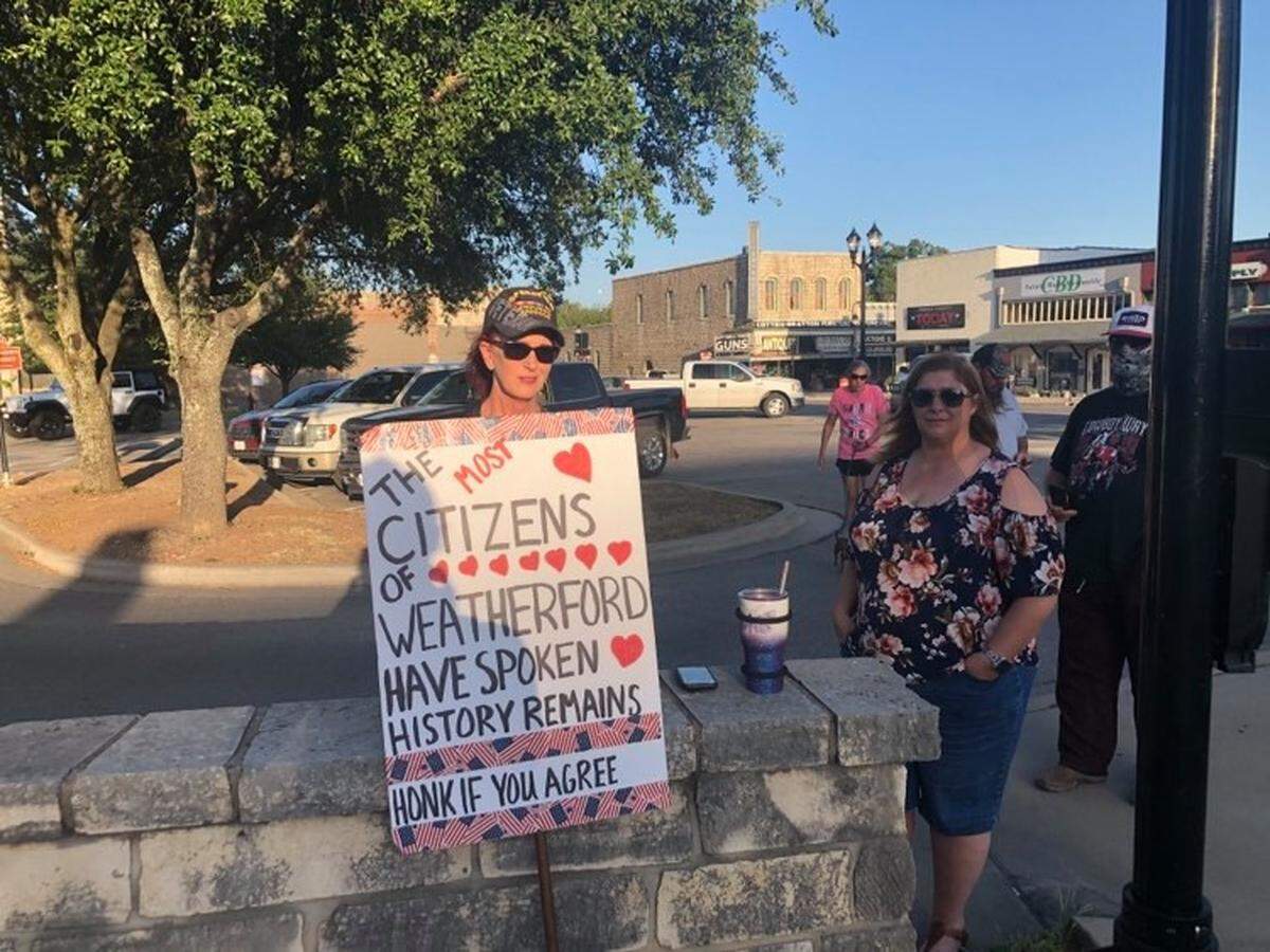 A woman and other counter-protesters stand across the street from the Parker County Courthouse, where protesters demanded the removal of a Confederate statue on Monday, Aug. 9.