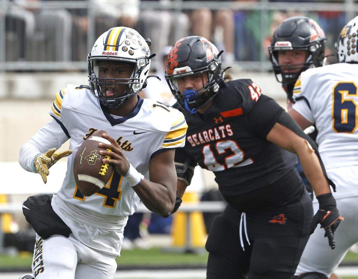 Fort Worth Arlington Heights quarterback Carmelo Carter (14) is pursued by Aledo defensive end Cooper Cyphers (42) during the first half of a UIL Class 5A Division I Regional on Friday Nov. 28, 2025 at Crowley ISD Multi-Purpose Stadium in Fort Worth, Texas.