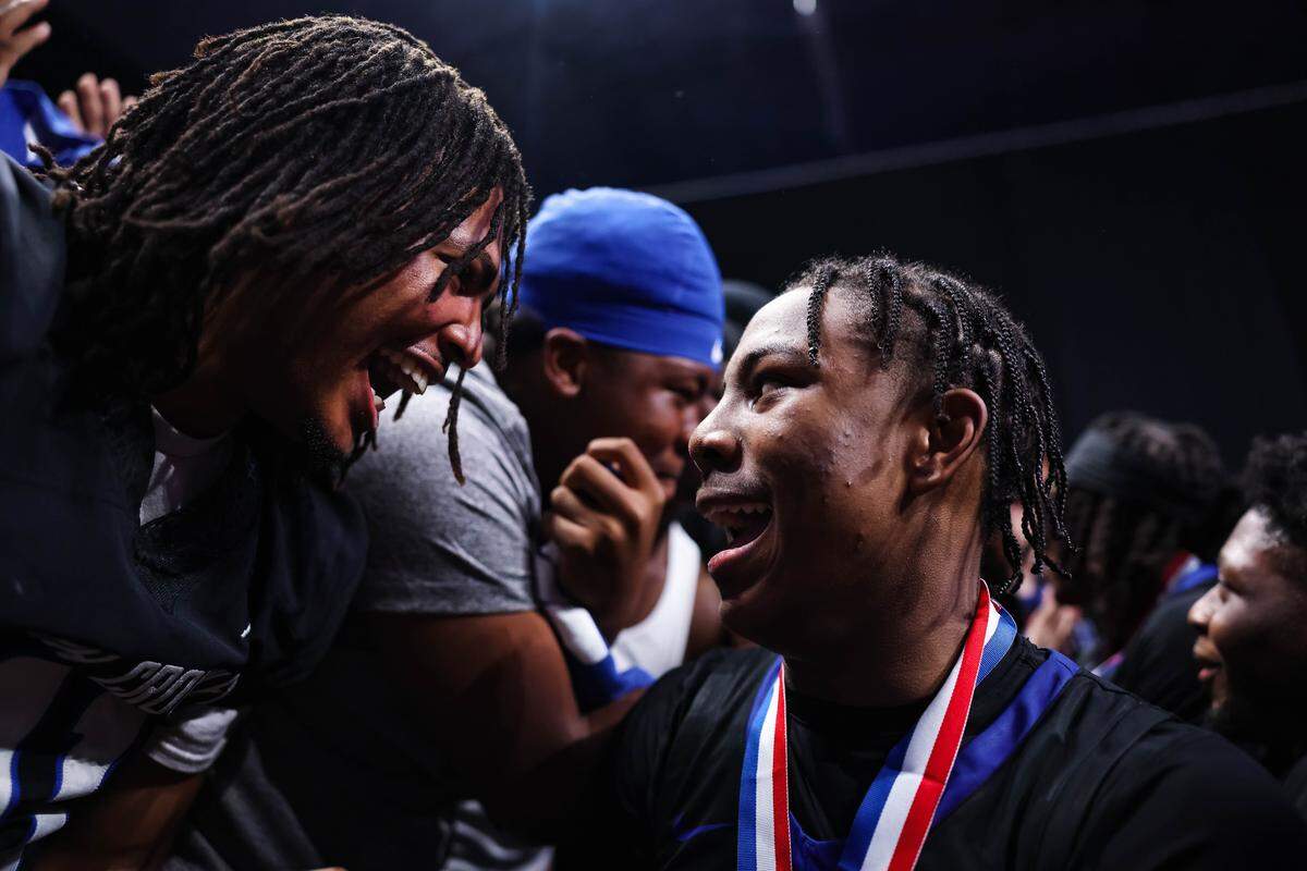 North Crowley guard Kameron Price (right) celebrates with a fellow student after winning the Class 6A Division I state championship game against San Antonio Brennan on Saturday at the Alamodome in San Antonio.