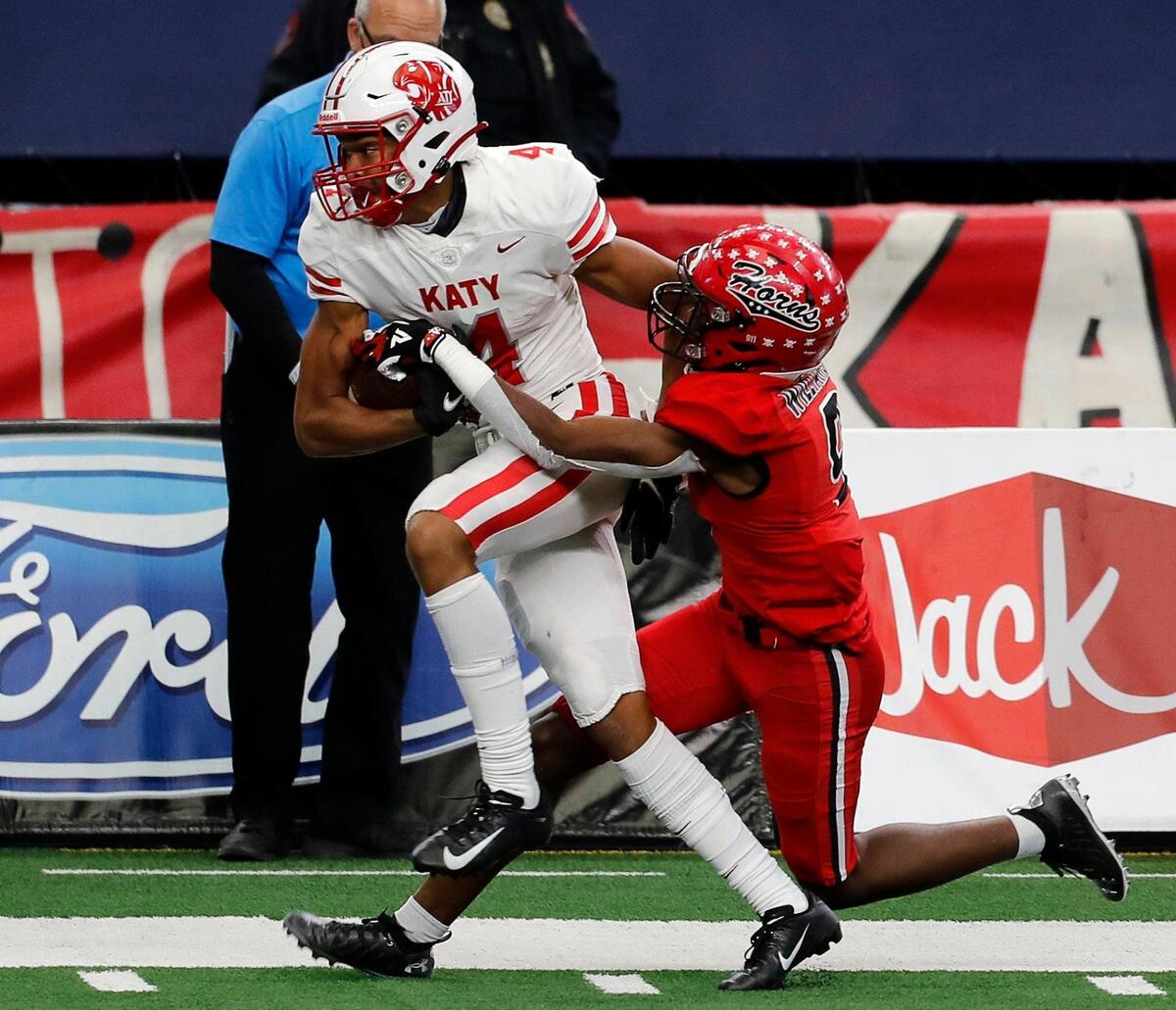 Katy wide receiver Nic Anderson (4) takes the ball down the sidelines in the grasp of Cedar Hill cornerback Amarian Williams (9) in the first half of the 6A D2 state title game at AT&T Stadium in Arlington, Texas, Saturday, Jan. 16, 2021. Katy led 24-0 after two frames. (Special to the Star-Telegram Bob Booth)