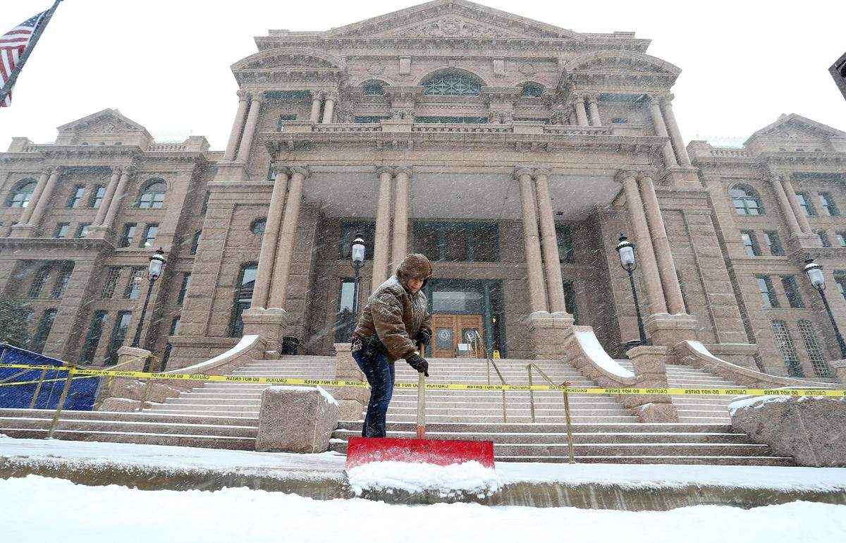Feb. 27, 2015: Ana Salazar clears snow at the old courthouse in downtown Fort Worth. Subfreezing temperatures, paired with morning snow, closed businesses and brought traffic to a standstill.