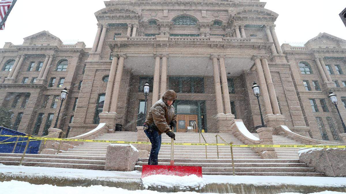Feb. 27, 2015: Ana Salazar clears snow at the old courthouse in downtown Fort Worth. Subfreezing temperatures, paired with morning snow, closed businesses and brought traffic to a standstill.