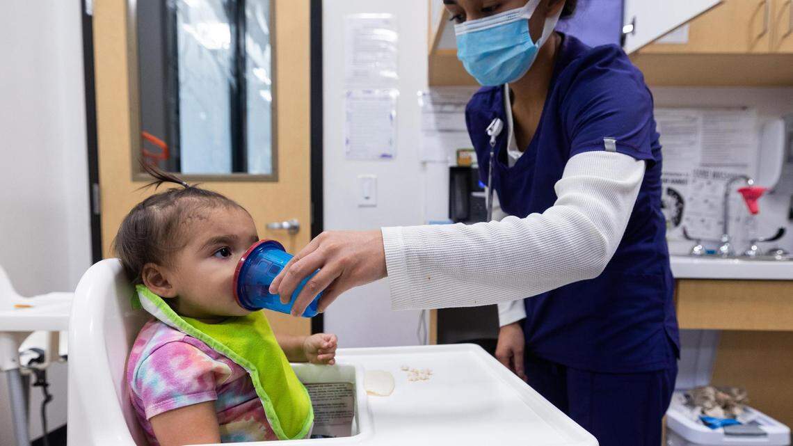 María García le da de beber a Riley Rodríguez, de 1 año, en Annie's Place en esta foto de archivo de octubre de 2022. Riley, su hermana y su madre han estado inscritas en el seguro médico Medicaid durante toda la pandemia del COVID-19.