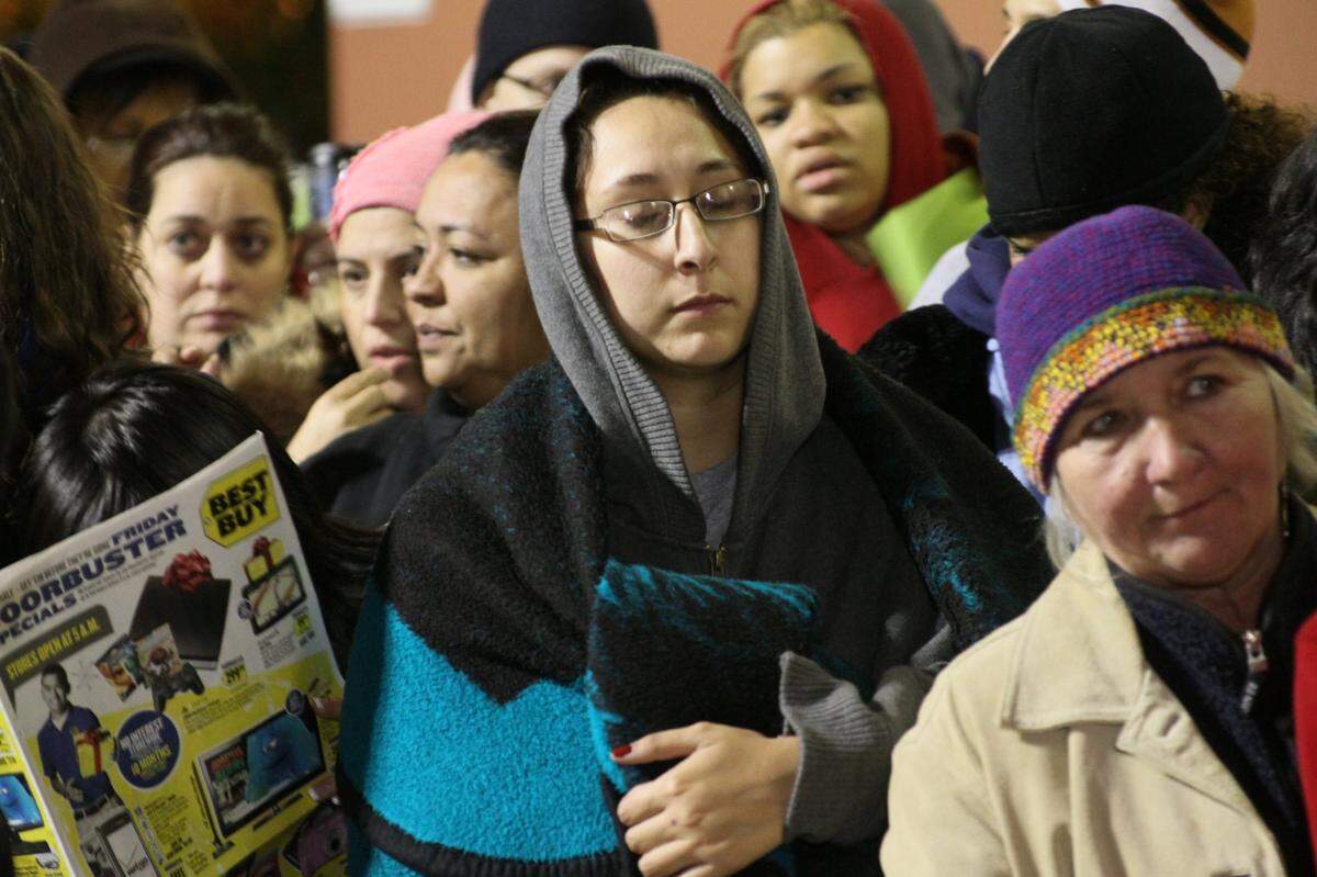 Nov. 27, 2009: Elizabeth Gutierrez stays warm as she waits for the Best Buy in Dallas to open. She arrived at the store at 9 pm Thursday.