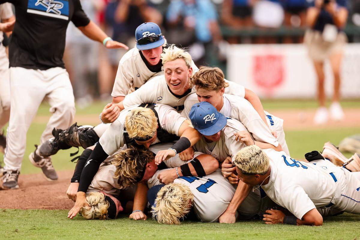 Robinson players dive on top of each other in a dog pile after defeating Brock 3-1 in the UIL Class 4A Division II baseball state championship game on Friday, June 5, 2026, at Dell Diamond in Round Rock, Texas.