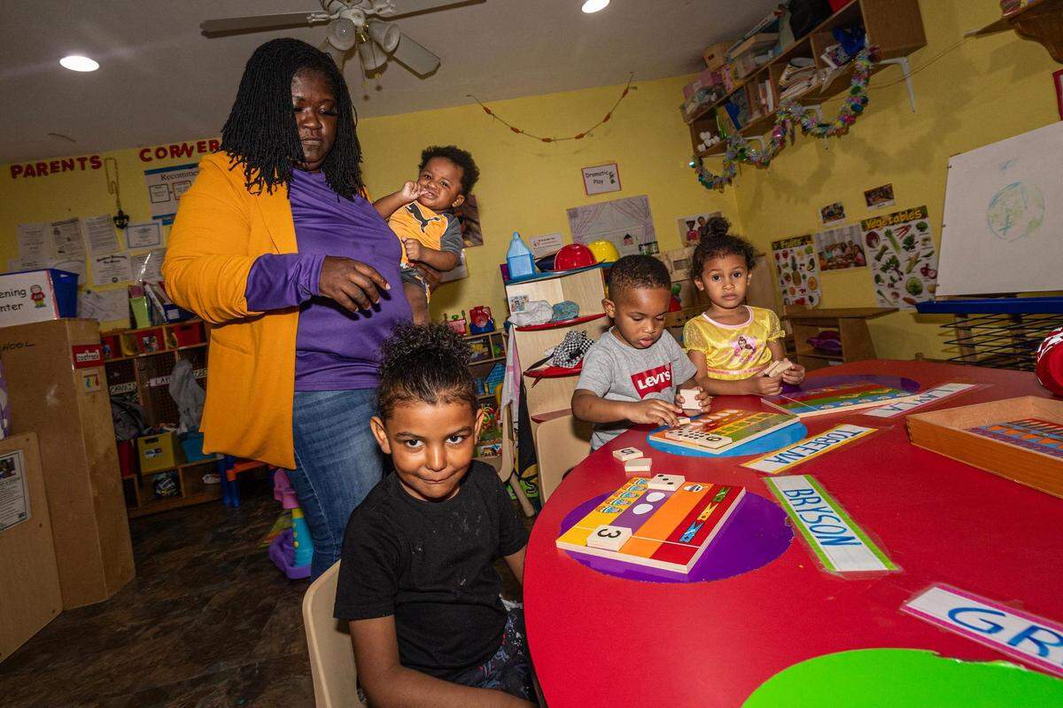 Child care home director Roslyn Chaney holds infant Kingston Wooten while teaching her students Bryson Harley, 5, Tobeena Emedosi, 3, and Layla Alston, 4, in the evening at the Future Scholars’ Childcare and Transportation child care home in Grand Prairie on Thursday, March 14, 2024. Future Scholars’ is one of few options in Tarrant County that provide 24/7 child care.