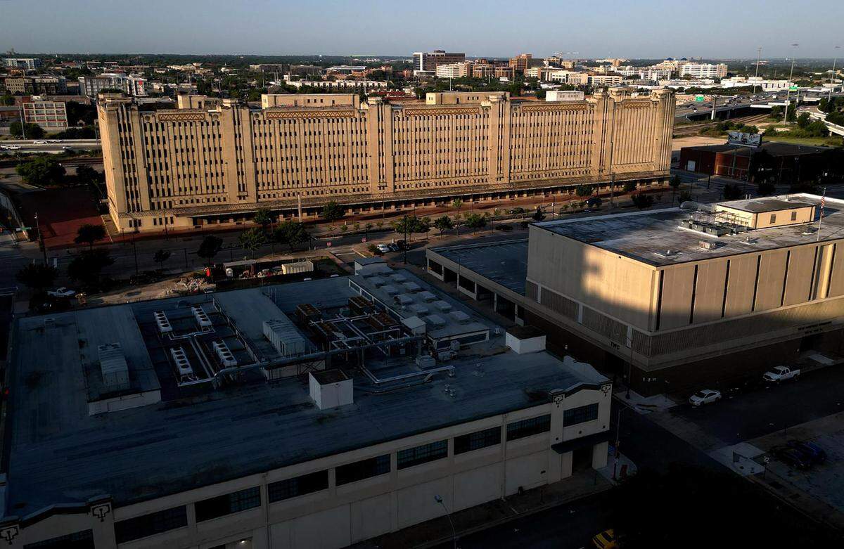An aerial view of a large historic brick building taking up most of a city block.
