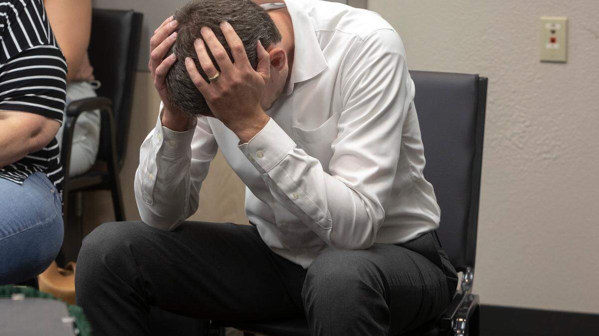 Chandler Crouch holds his head in his hands during an emergency board meeting at the Tarrant Appraisal District in June. Crouch and supporters arrived to defend him against a complaint filed by a TAD director.