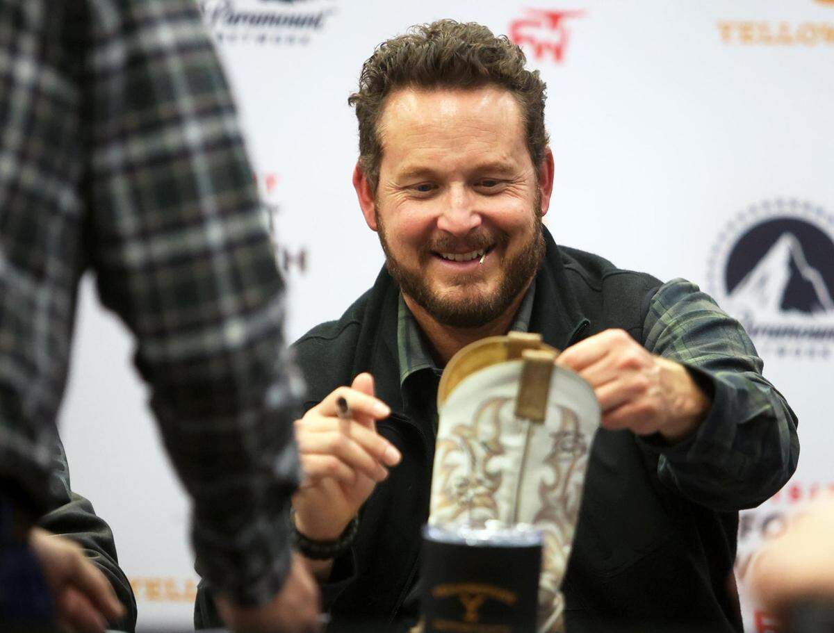 Cole Hauser, who plays Rip Wheeler on ‘Yellowstone’ signs a pair of cowboy boots for a fan at the Fort Worth Stock Show & Rodeo on Tuesday, February 1, 2022. Also present was Eric Nelsen from ‘1883’ and screenwriter Taylor Sheridan.