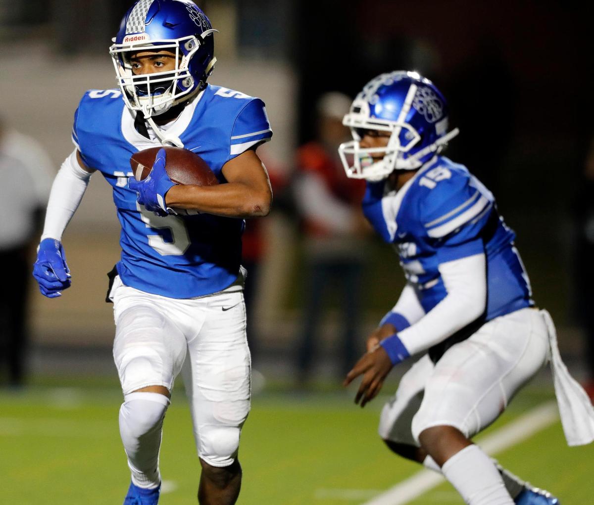 Brewer running back Keiran Patrick-Daniels (5) takes the ball from quarterback Jaylen Spriggs (15) and heads to the left side in a District 3-5A football game at Bear Stadium in White Settlement, Texas, Friday Oct. 29, 2021. Northwest led 21-10 at the half. (Special to the Star-Telegram Bob Booth)