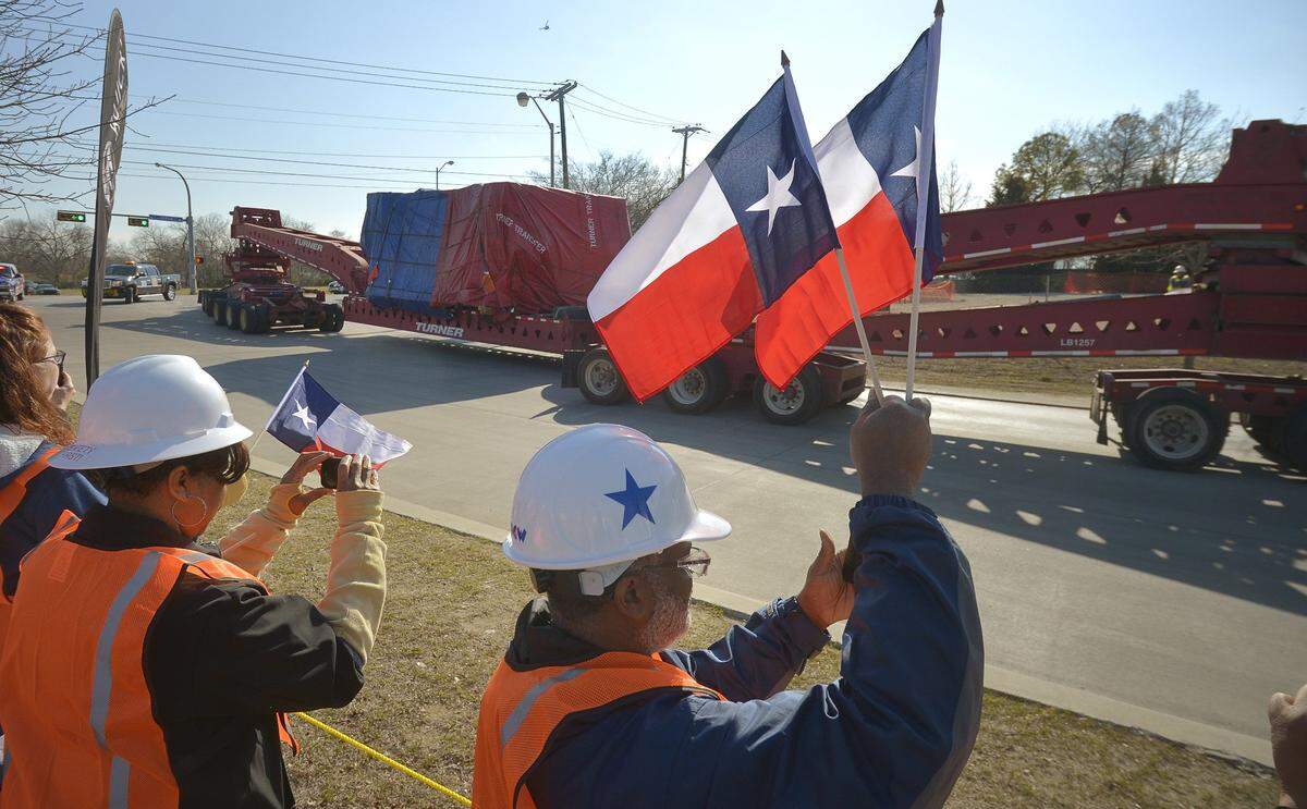 March 1, 2013: GM stamping employees wave Texas flags as the new stamping machinery arrives at General Motors assembly plant in Arlington. The delivery of 5 million pounds of new stamping presses and equipment is the latest investment in the plant. The stamping facility will make components for new GM full-size SUVs.