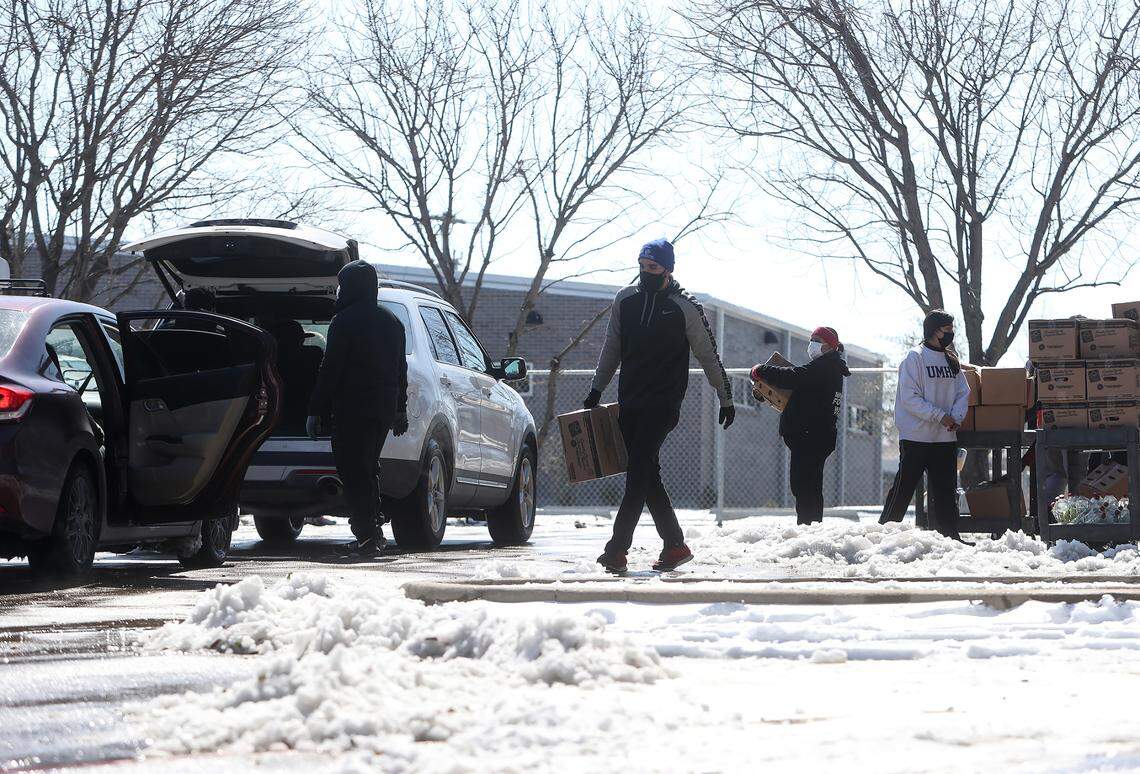 Staff with the Boys & Girls Clubs of Greater Tarrant County load food into cars during a food distribution in partnership with Tarrant Area Food Bank on Friday, February 19, 2021. A line of vehicles wrapped around a two block area when the distribution began at noon at the Hemphill location.