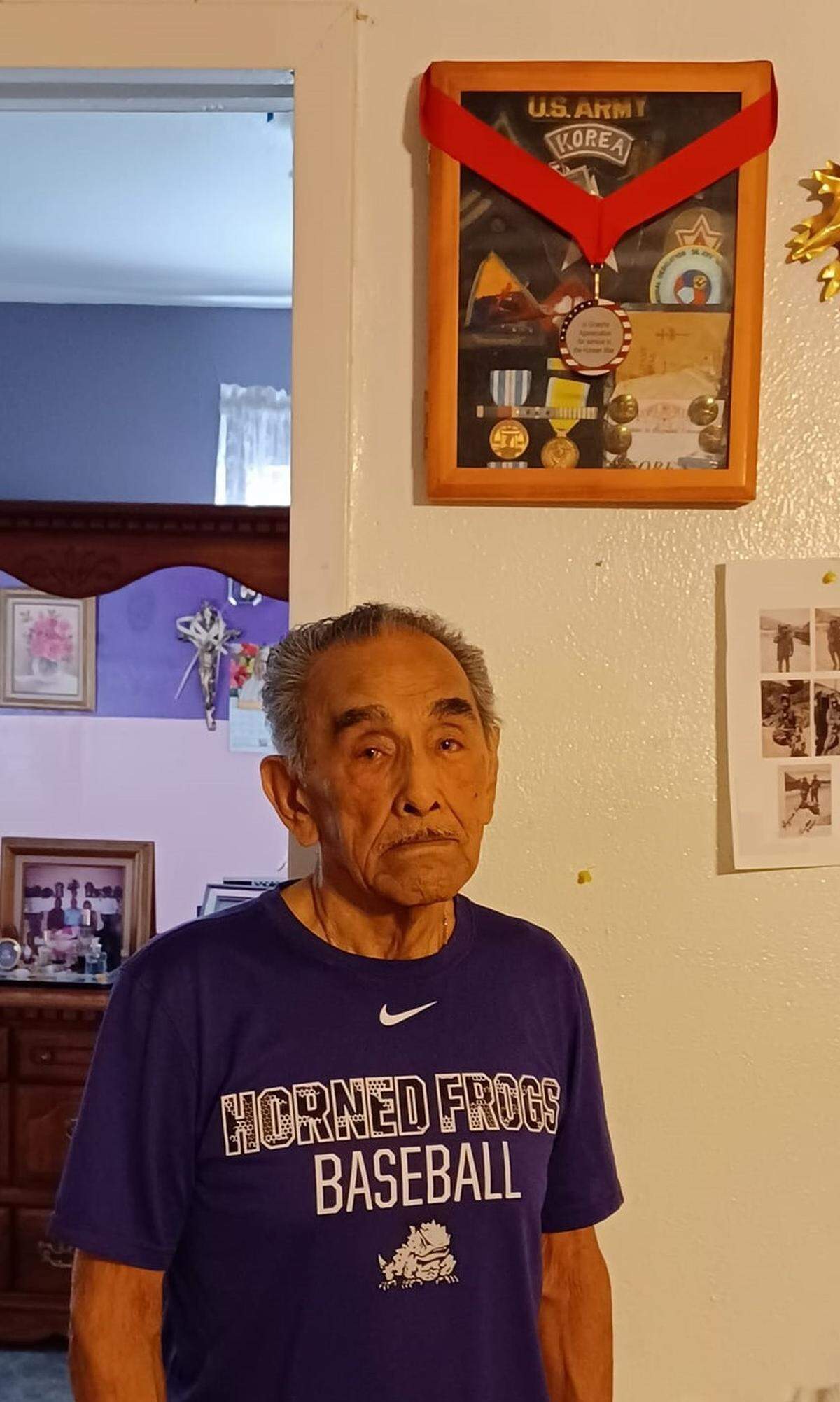 Paul Vasquez stands in front of his Korean War medals.