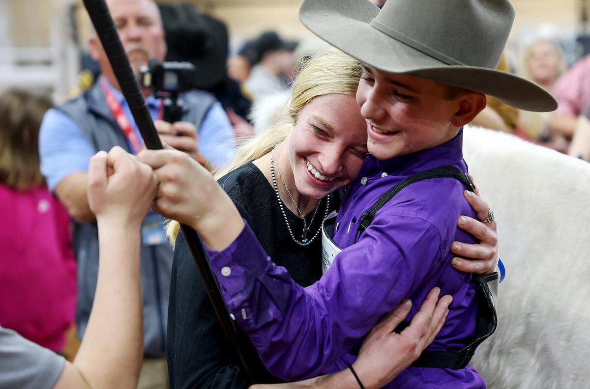 Caiman Cody, 13, of Tolar, right,  hugs family friend  Kendall Rudiger while fist bumping his little brother Maverick after his steer White Castle was declared  the 2026 Junior Steer Show Grand Champion at the Fort Worth Stock Show & Rodeo on Friday, Feb. 6, 2026.
