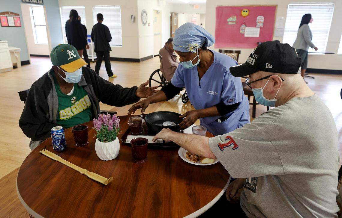 Certified nursing assistant Regina Asara serves residents lunch at Heritage at Turner Park in Grand Prairie. 