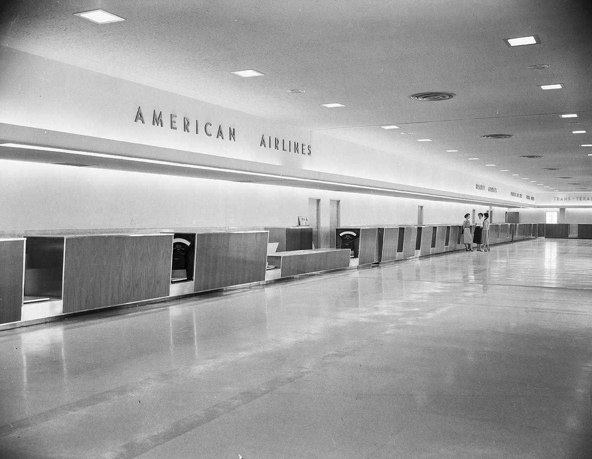The new terminal and check-in counters is shown largely empty, with women in the distance.