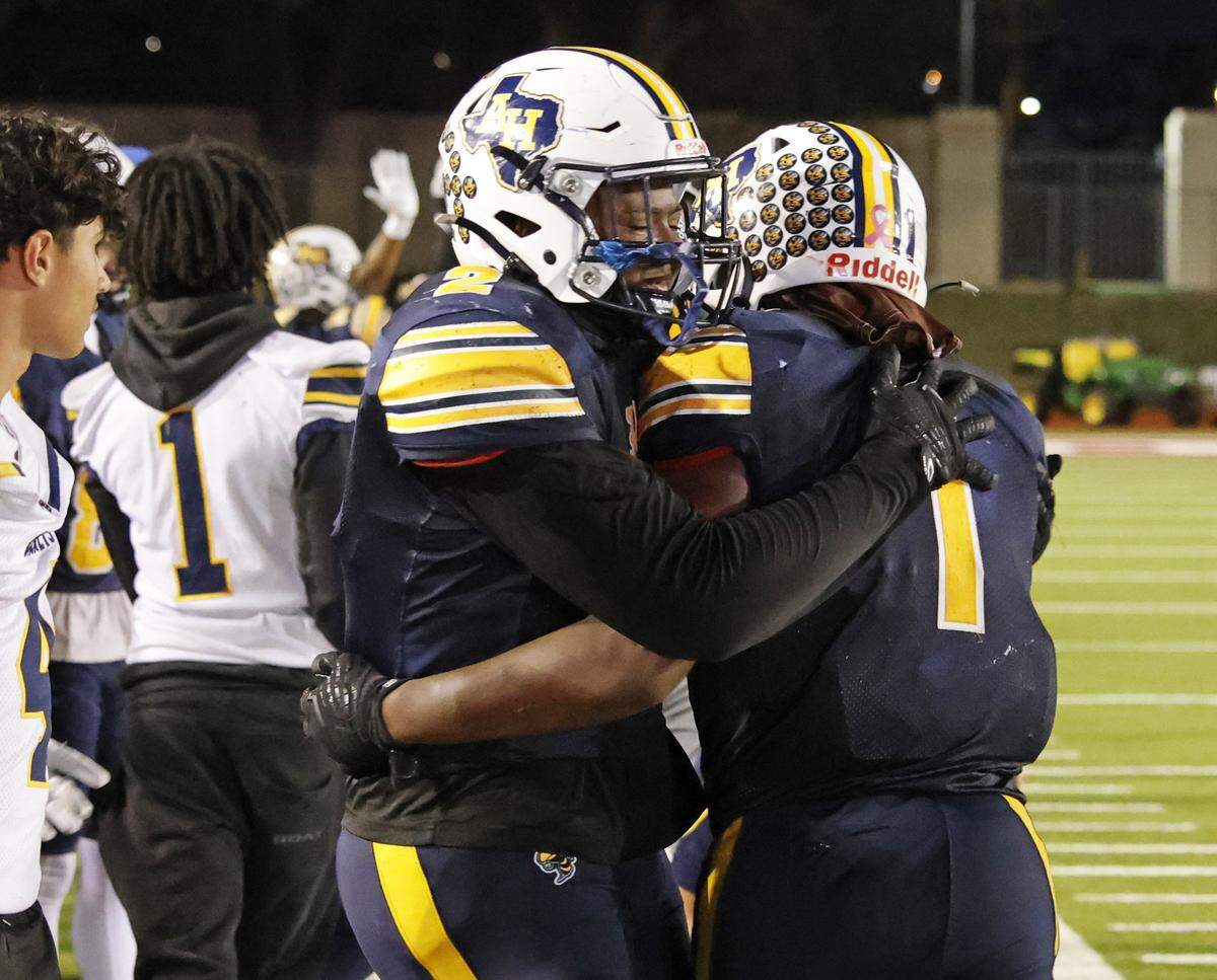 Arlington Heights running back Carson James (1) is congratulated on the sidelines by his brother, defensive lineman Carter James (2), during the second half of a UIL Conference 5A D1 Bi-District playoff game between Arlington Heights and Brewer at Farrington Field in Fort Worth, Texas, Friday, Nov. 14, 2025.