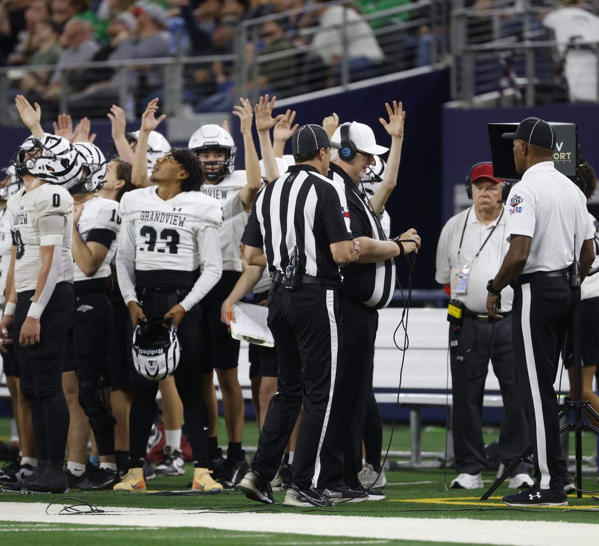 Officials review the previous play and ultimately overturn the call as Grandview players signal touchdown against Yoakum while watching the big screen during the second half of the UIL Class 3A Division I championship game on Thursday Dec. 18, 2025 at AT&T Stadium in Arlington, Texas.