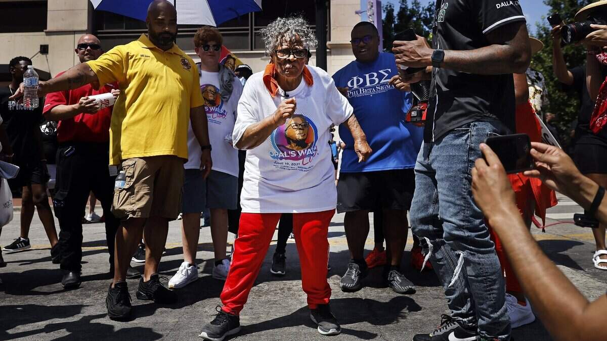 During her walk through downtown Fort Worth, Texas, Opal Lee, middle, stops in the middle of Commerce Street and dances to a live music performance on Saturday, June 19, 2021. For the first time since her dream of Juneteenth being made a national holiday became reality, Lee led a 2.5 mile caravan from Historic Southside to the Tarrant County Courthouse in downtown Fort Worth. Lee, 94, marked Juneteenth by speaking with supporters at the historic courthouse after cooling down from the hot walk. (Tom Fox/The Dallas Morning News/TNS)