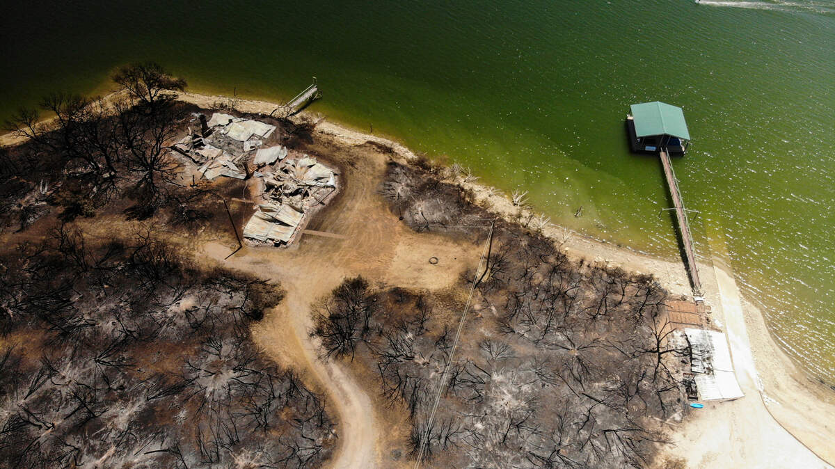 Charred trees and remains of a structure are left after a wildfire Monday, July 25, 2022, near Possum Kingdom Lake.