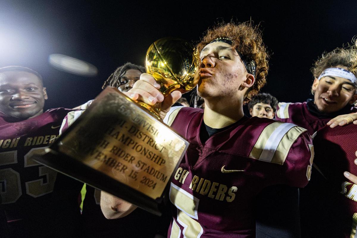 Saginaw quarterback Roman Morales (5) kisses the district championship trophy after defeating Azle 41-39 in the Class 5A Division I playoffs game at Rough Rider Stadium in Saginaw on Friday, Nov. 15, 2024. Morales threw the game-winning touchdown to seal Saginaw High School’s first playoff win in school history.