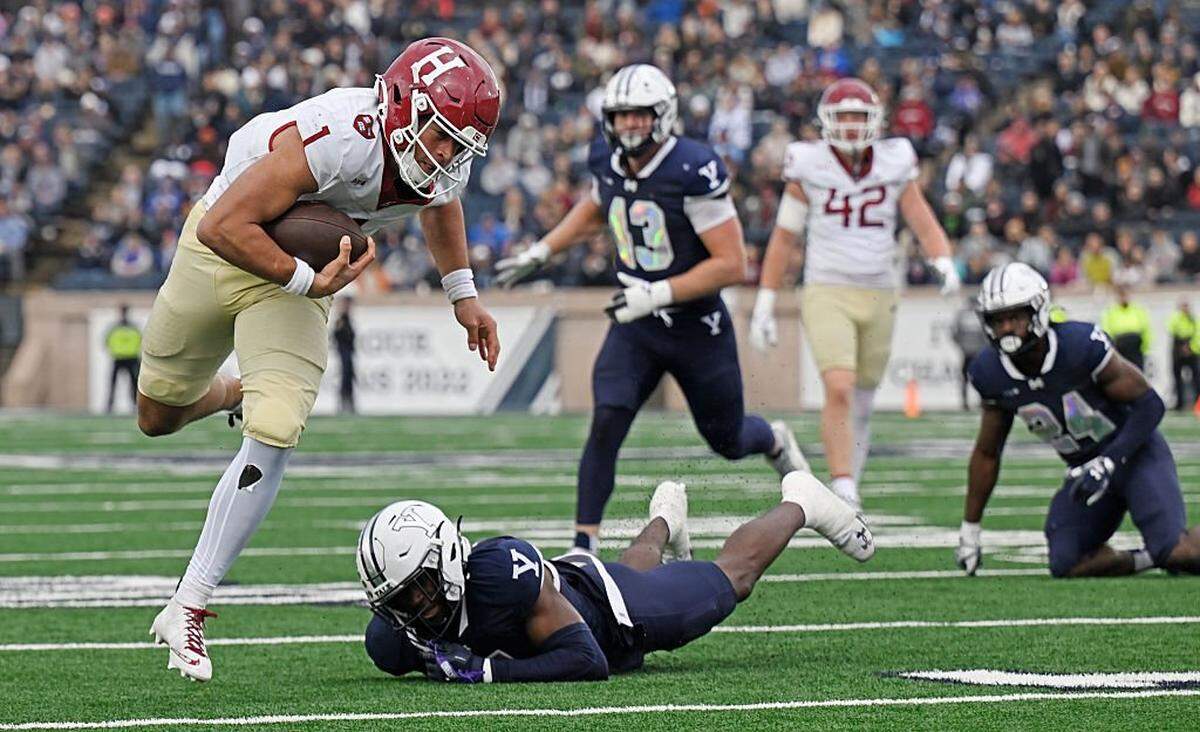 NEW HAVEN, CONNECTICUT - NOVEMBER 22: Jaden Craig #1 of the Harvard Crimson breaks free from Brandon Webster #7 of the Yale Bulldogs in the first half of the 141st playing of "The Game" at Yale Bowl on November 22, 2025 in New Haven, Connecticut. (Photo by Sean D. Elliot/Getty Images)