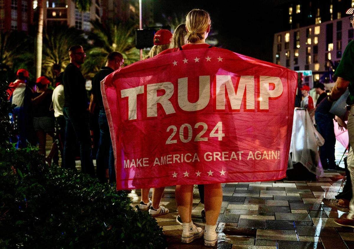 Hailey Olson holds a Trump flag outside the Palm Beach County Convention Center where former President Donald Trump is having his election party on November 5, 2024, in West Palm Beach, Florida.