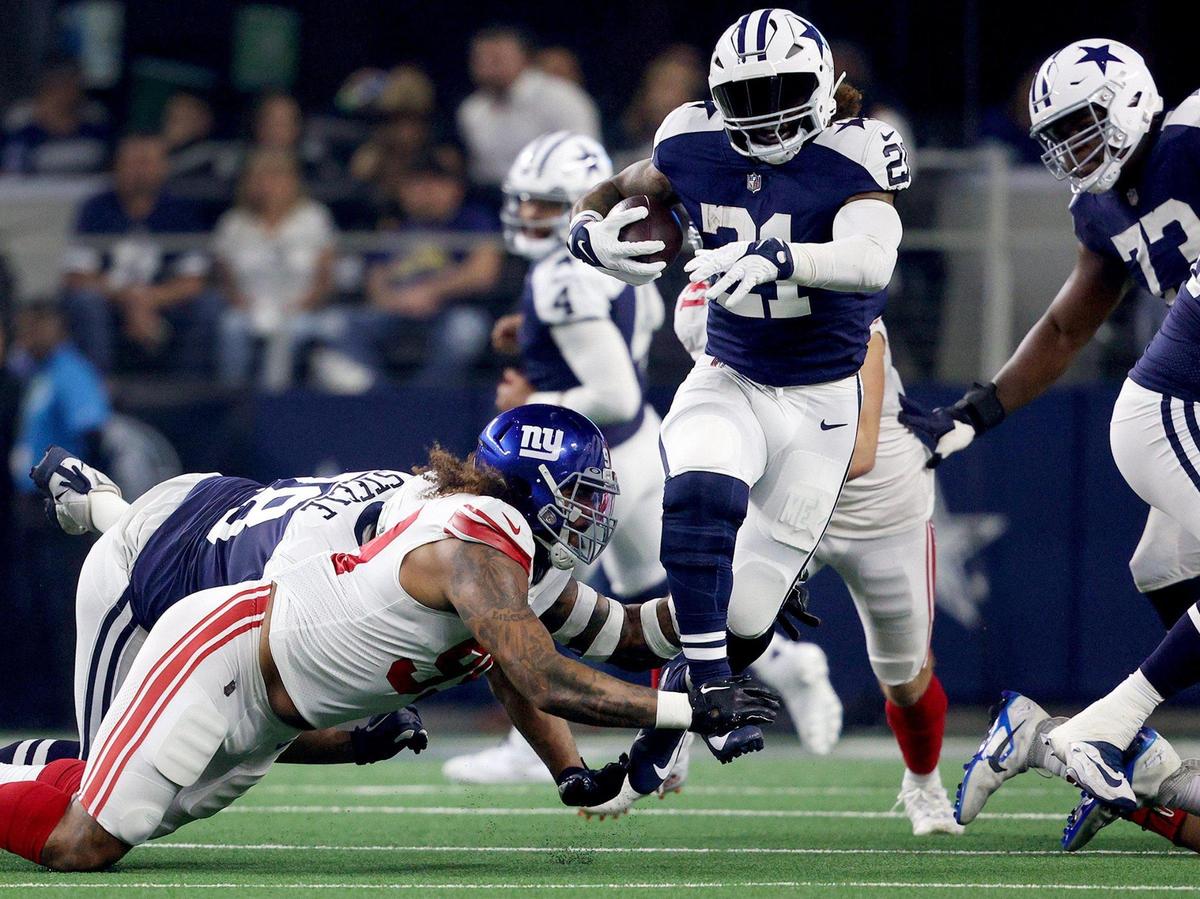 Dallas Cowboys running back Ezekiel Elliott slips from New York Giants defensive tackle Leonard Williams’ grasp while running the ball on Thursday, November 24, 2022, at AT&T Stadium in Arlington.