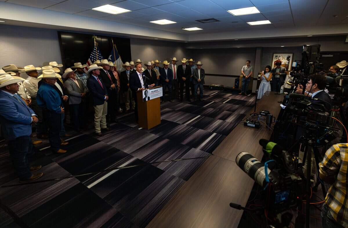 Texas Attorney General Ken Paxton speaks while a group of law enforcement stand behind him during a press conference event at Hampton Inn & Suites in Fort Worth on July 21, 2026.