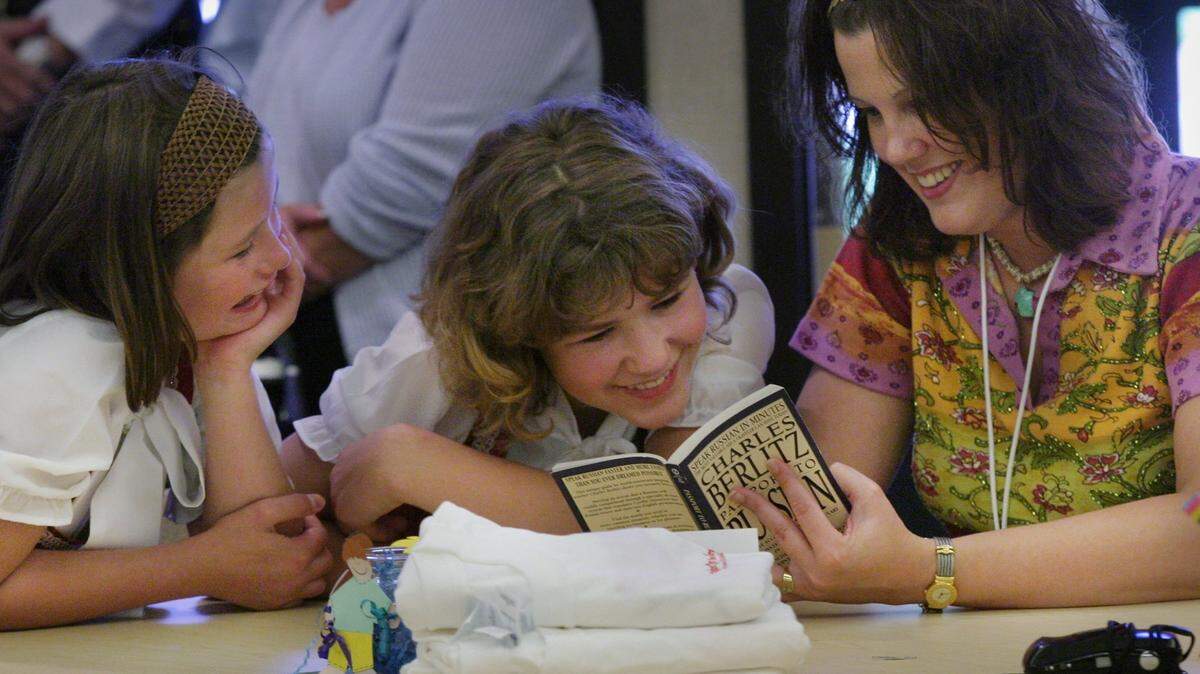 In this 2003 photo, 11-year-old Elena and her 13-year-old sister Tamara try to communicate using a Russian phrasebook with host Jennifer Effendi as Russian orphans met host families at the Gladney Center for Adoption. (Star-Telegram file photo)