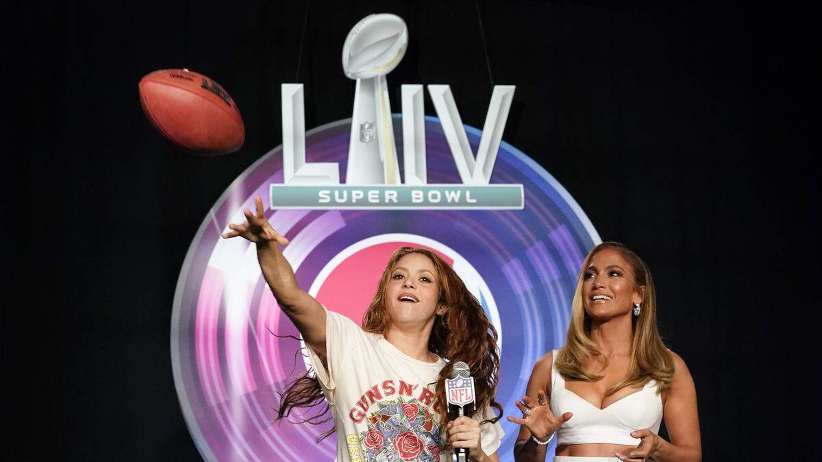 NFL Super Bowl 54 football game halftime performer Jennifer Lopez and Shakira throws a football at a news conference Thursday, Jan. 30, 2020, in Miami. (AP Photo/Morry Gash)
