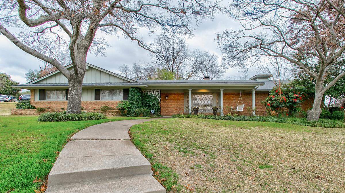 The home at 6495 Woodstock Road features a spacious front yard.